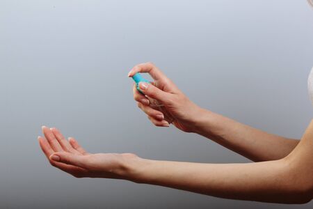 Closeup of pretty woman's hand doing press spray alcohol for sterilize virus.の写真素材