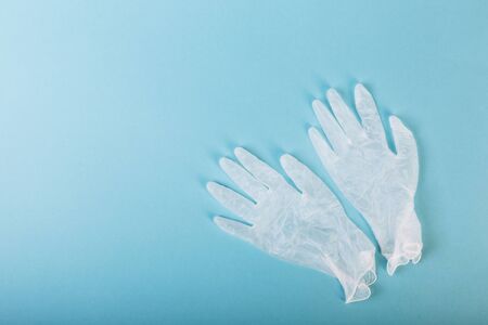 Whitte surgical gloves isolated on the blue background. Concept protect against infection or contamination.の写真素材