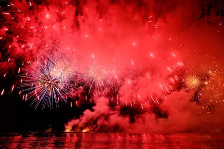 Holiday fireworks above water with reflection on the black sky background okの写真素材