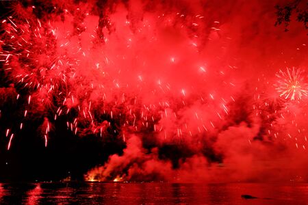 Holiday fireworks above water with reflection on the black sky background okの写真素材