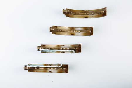 A couple of hand drum brake pads are lying on the white surface before replacement operation.の写真素材