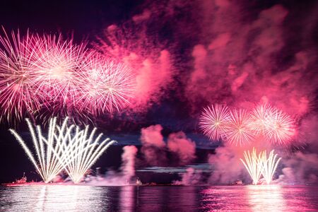 Holiday fireworks above water with reflection on the black sky background okの写真素材
