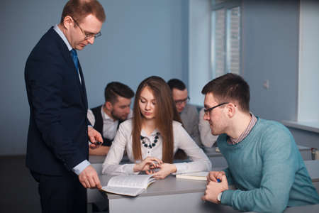 2016.01.17 Business school training in the Samara State University. Portrait of happy teacher standing and discussing in classroom with students in backgroundのeditorial素材