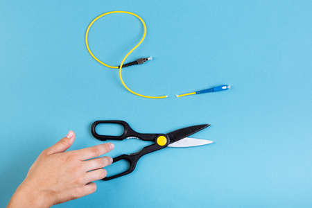 Destroy optical SC fiber by scissors. Isolated on blueの写真素材