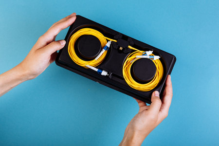 Woman hands hold blue variable optical attenuator on blue backgroundの写真素材