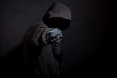 Killer in black holds the knife in aggressive style. Selective focus.の写真素材