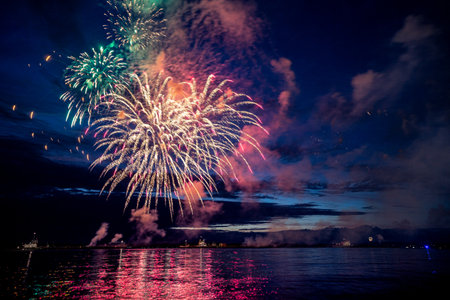 Colorful fireworks reflect from water, beautiful sceneryの写真素材