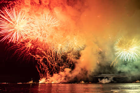 Holiday fireworks above water with reflection on the black sky backgroundの写真素材