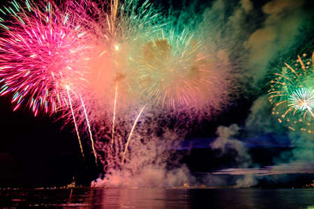 Holiday RED fireworks above water with reflection on the black sky backgroundの写真素材