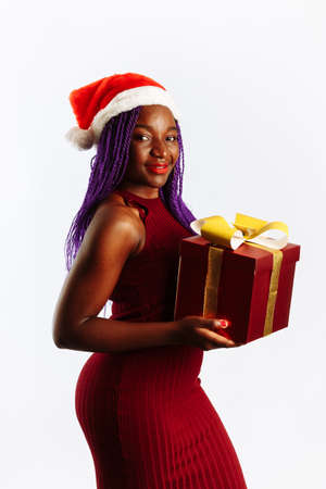 Happy African Santa Woman is smiling and holding Gift Box for Christmas or New Year. Isolated on white backgroundの写真素材