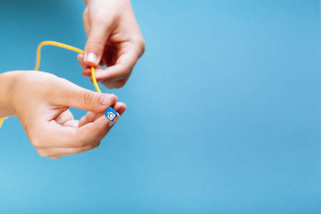 womans hands hold SC and FC connector fiber optic patch cord single mode on blue backgroundの写真素材