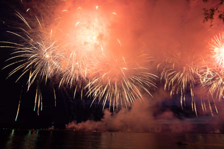 Holiday fireworks above water with reflection on the black sky backgroundの写真素材