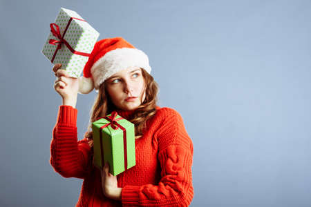 Happy europian Santa Woman is smiling and holding Gift Box for Christmas or New Year. Isolated on gray backgroundの写真素材
