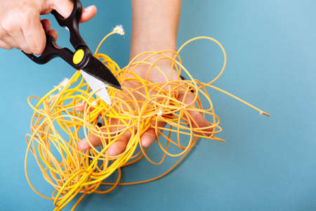 Destroy optical fiber with scissors. Isolated on blueの写真素材