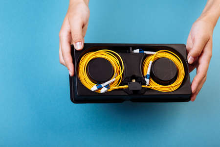 Woman hands hold blue variable optical attenuator on blue backgroundの写真素材