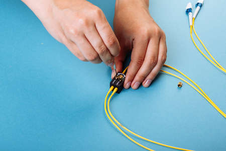 Hand tune an optic attenuator with a screwdriver. Blue backgroundの写真素材
