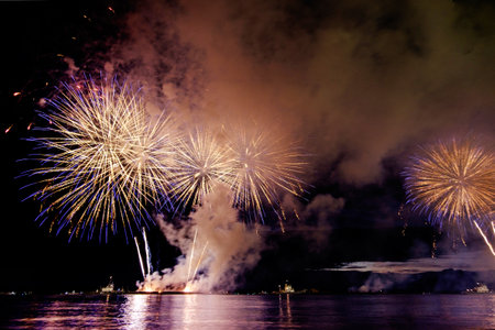 Holiday fireworks above water with reflection on the black sky background okの写真素材