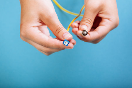 womans hands hold SC and FC connector fiber optic patch cord single mode on blue backgroundの写真素材