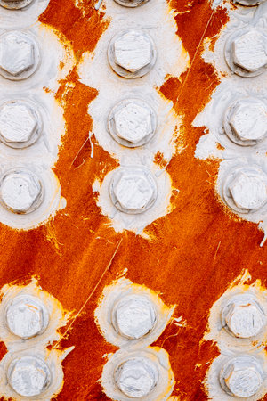 The texture: abstract background of bolts and nuts painted white on a red backgroundの写真素材