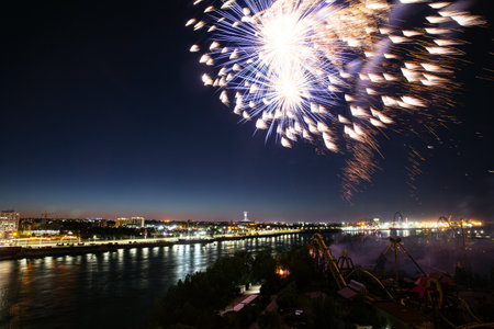 Holiday fireworks above water with reflection on the black sky background.