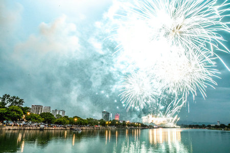 Holiday fireworks above water with reflection of the downtown in the backgroundの写真素材