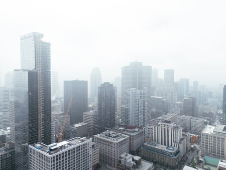 Drone flight in the downtown city skyline, foggy daytime view of Montreal, Quebec, Canadaの写真素材