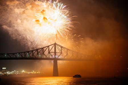 Drone flight through holiday fireworks above water with reflection on the black sky background