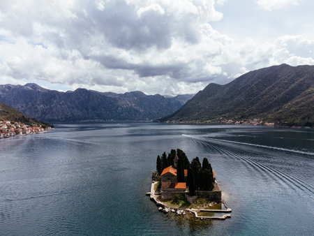 Aerial view of Saint George Island near Perast in the Bay of Kotor, Montenegro, surrounded by calm sea and mountains. g.の写真素材
