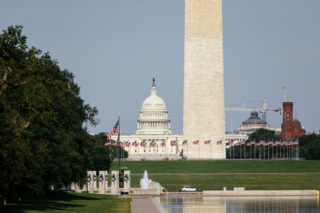 View of the US Capitol behind the Washington Monument and American flags on the National Mall. g.