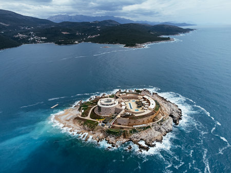 Aerial view of historic coastal fortress on Adriatic Sea islet in Montenegro, surrounded by rugged shoreline. c.の写真素材