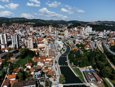 Aerial view of Uzice city in western Serbia with river, modern buildings, and surrounding green hills. g.の写真素材