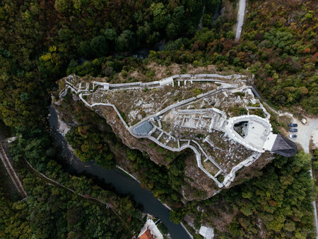 Medieval cliff-top fortress overlooking river and red-roofed town in Uzice, Serbia, with winding road. g.の写真素材