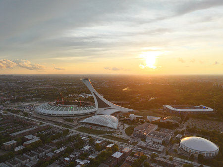 Aerial view of Olympic Stadium in Montreal at sunset with colorful sky and city landscape. g.