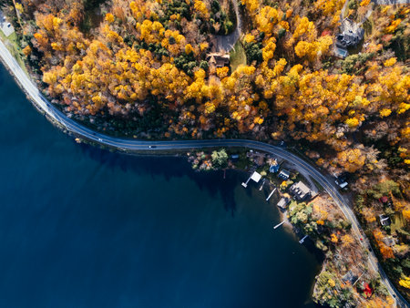 Drone aerial of a winding lakeside road with residential buildings and autumn forest in Canada. g.の写真素材