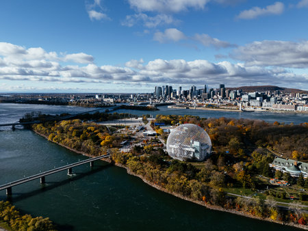 Aerial view of Montreal Biosphere with autumn trees, river and modern city skyline under blue sky. g.の写真素材