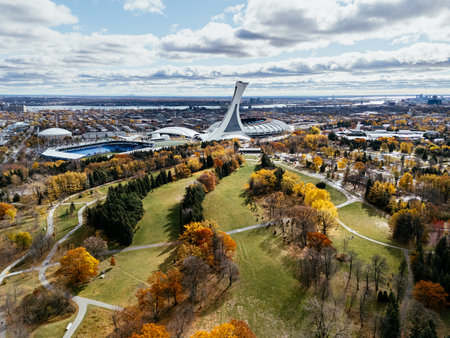 Aerial view of Olympic Stadium renovation, and botanical garden fall colors in Montreal park under cloudy sky. g.の写真素材