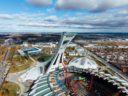 Aerial view of Olympic Stadium renovation, and botanical garden fall colors in Montreal park under cloudy sky.の写真素材