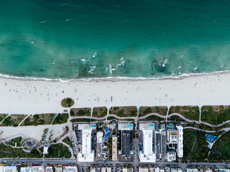Aerial view of Miami South Beach, Florida turquoise ocean, white sand, umbrellas, hotels, and beachgoers*の写真素材