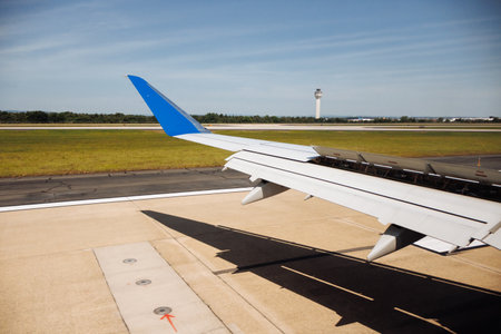 Airplane wing view during taxiing on airport runway under clear blue sky on a sunny day. g.の写真素材