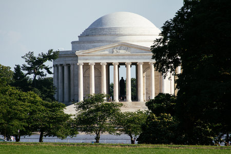 Jefferson Memorial framed by trees on a sunny day in Washington DC, USA, iconic neoclassical...
