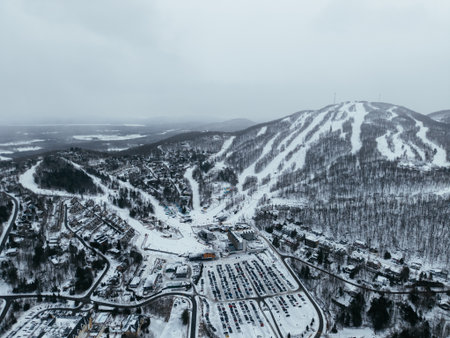 Aerial winter view of Bromont ski resort with snowy slopes, village and parking area in Quebec, Canada. g.の写真素材