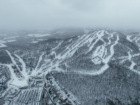 Aerial winter view of Bromont ski resort with snowy slopes, village and parking area in Quebec, Canada. g.の写真素材