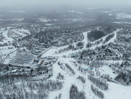 Aerial winter view of Bromont ski resort with snowy slopes, village and parking area in Quebec, Canada. g.の写真素材