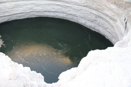 Burning Darvaza gas crater in Karakum Desert at sunset, natural fire pit in Turkmenistan.の写真素材