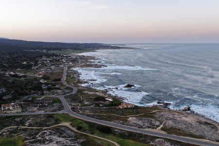 Aerial sunset over Monterey Bay coastline with ocean waves and scenic California landscape.
