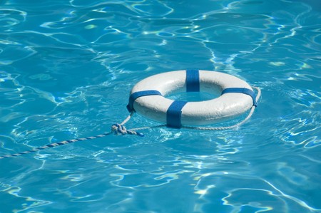 Life ring floating on top of sunny blue water