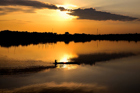 fishmonger in his traditional boat at sunriseの写真素材