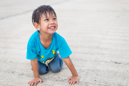 Happy asian kid smile sitting on drivewayの写真素材