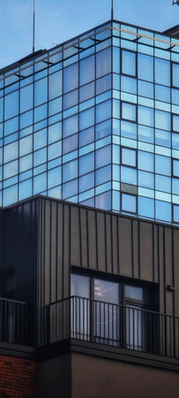 Modern building facade with glass windows, metal panels and balcony railingの写真素材