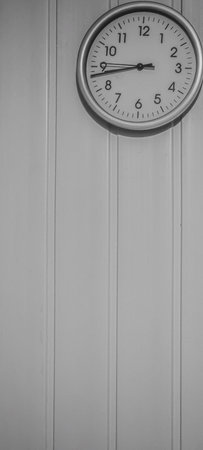 Minimalist grayscale wall clock on paneled interior wallの写真素材